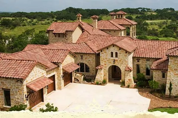 Front view of a large, high-end home with a rust colored tile roof expertly installed by Fry Roofing Inc